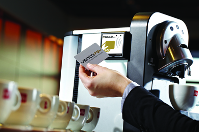 Hand hält Chipkarte vor Kaffemaschinen Automatenmodul