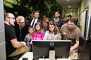 Mehrere Personen stehen vor Computer-Bildschirm