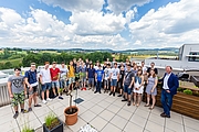Eine Schulklasse steht auf der Dachterasse, auf dem Foto sieht man den Ausblick auf den Softwarepark Hagenberg.