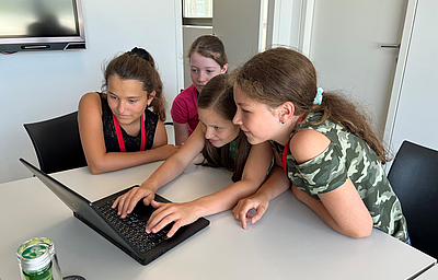4 Mädchen sitzen vor einem Laptop