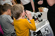 Kind beobachtet Fasern und Textilien durch das Mikroskop