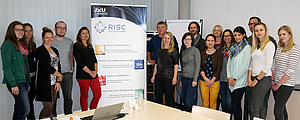 7 Personen stehend neben Roll-up der RISC Software GmbH